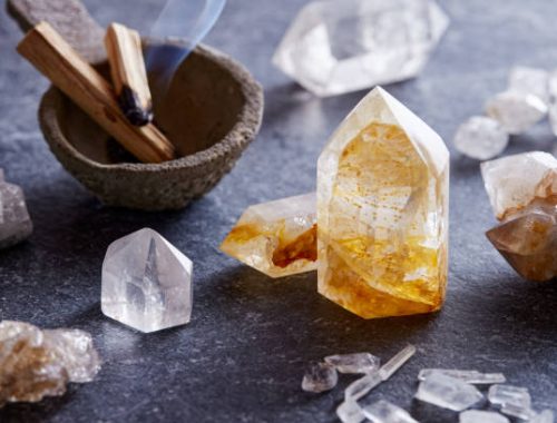 Gemstone crystals set on granite surface with burning palo santo wood, for spiritual and holistic therapy. Energy healing minerals set ready for spiritual practice and alternative medicine. Purification ritual with gem stones crystal and palo santo wood sticks.